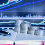 Stack of money coin with trading graph.